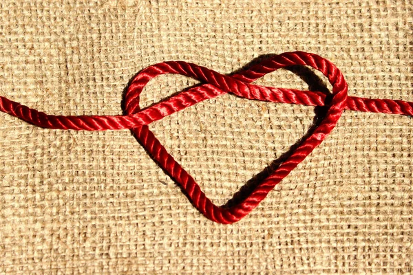 Red Thread Knotted In A Heart Shape.Abstract Love Background.  Abstract Textile Textures Background.