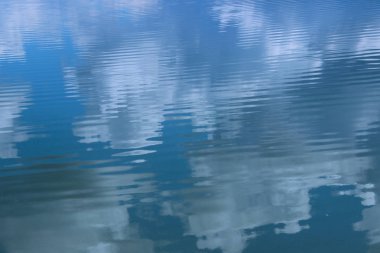 Suda gökyüzü yansıması. Güzel doğa arka plan. Mavi renkler arka plan.