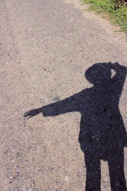 Şapka takan ve yolda duran bir kadının gölgesi. İnsanlar, seyahat konsepti.
