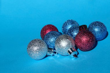 Mavi arka plan üzerinde Noel dekorasyonu. Tatiller, Noel oyuncakları konsepti. Mavi arka plan üzerinde mavi, kırmızı ve gümüş Noel topları.