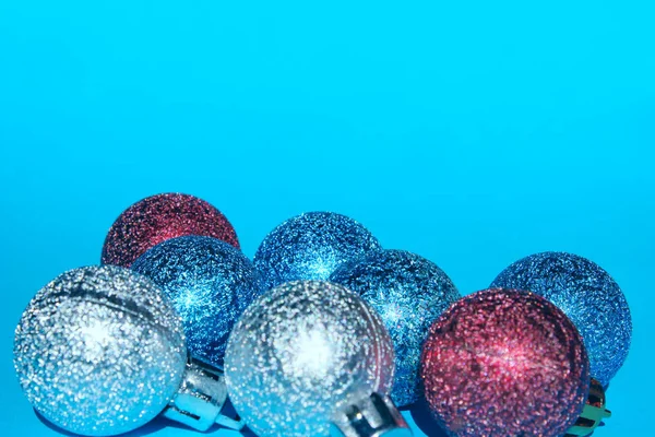 Christmas decoration over blue background. Holidays, Christmas toys concept. Blue, red and silver Christmas balls over blue background.