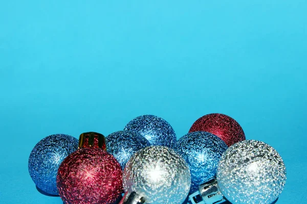 Christmas decoration over blue background. Holidays, Christmas toys concept. Blue, red and silver Christmas balls over blue background.