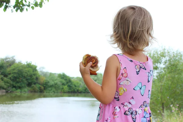 Çörek Tutan Göle Bakan Tatlı Küçük Bir Kız Arka Manzara — Stok fotoğraf