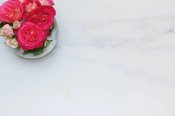 vase of roses. marble surface. flat lay
