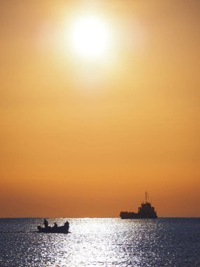 Gündoğumu sırasında denizde gemi