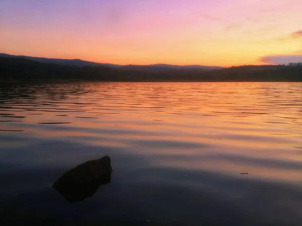 Foggy Lake in the mountains at the sunset in the evening