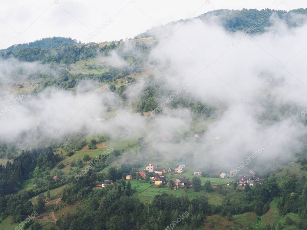 Fog at the village in the carpatian mountains 