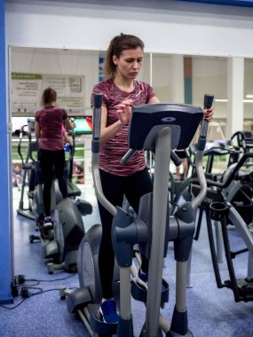 Genç model kız spor salonunda aynanın önünde egzersiz yapıyor. 