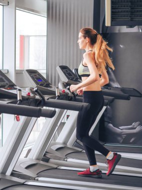 Genç kız spor salonunda egzersiz yapıyor.