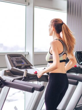 Genç kız spor salonunda egzersiz yapıyor.