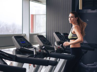 Genç kız spor salonunda egzersiz yapıyor.