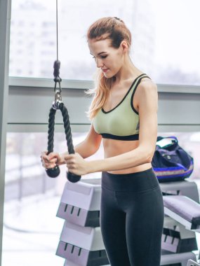 Genç kız spor salonunda egzersiz yapıyor.