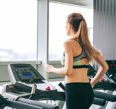 Genç kız spor salonunda egzersiz yapıyor.