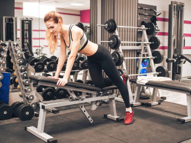 Genç kız spor salonunda egzersiz yapıyor.