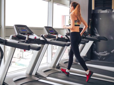 Genç kız spor salonunda egzersiz yapıyor.