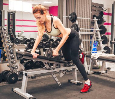 Genç kız spor salonunda egzersiz yapıyor.