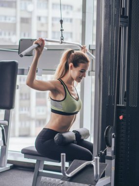 Genç kız spor salonunda egzersiz yapıyor.