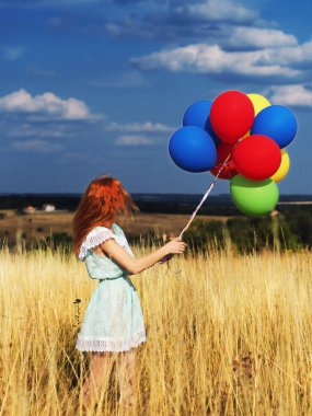 Sarı spikelets ve b ballons ile duran kız redhead
