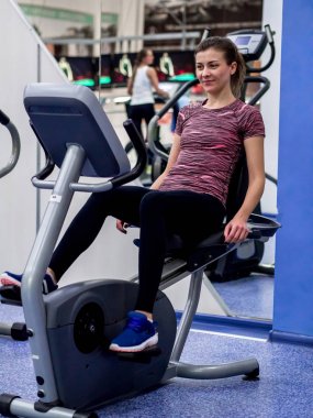 Genç model kız spor salonunda aynanın önünde egzersiz yapıyor. 