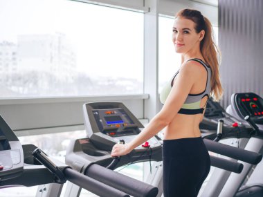 Genç kız spor salonunda egzersiz yapıyor.