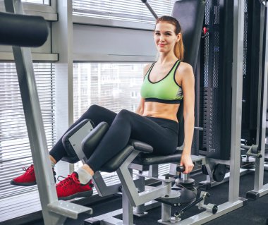 Genç kız spor salonunda egzersiz yapıyor.