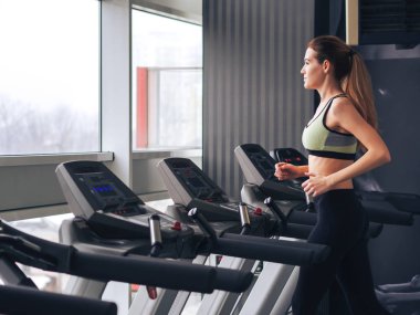 Genç kız spor salonunda egzersiz yapıyor.