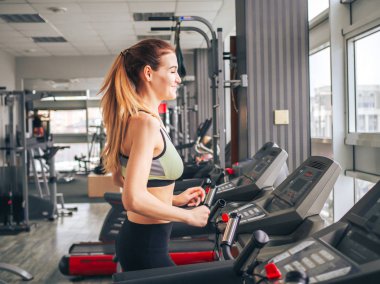 Genç kız spor salonunda egzersiz yapıyor.