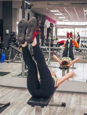 Genç kız spor salonunda egzersiz yapıyor.