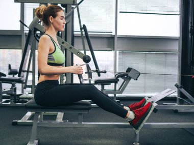 Genç kız spor salonunda egzersiz yapıyor.