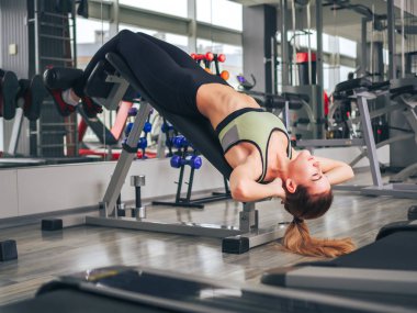 Genç kız spor salonunda egzersiz yapıyor.