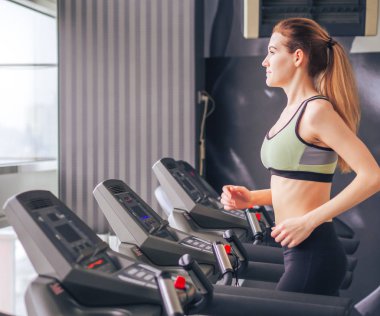 Genç kız spor salonunda egzersiz yapıyor.