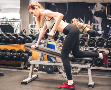 Genç kız spor salonunda egzersiz yapıyor.