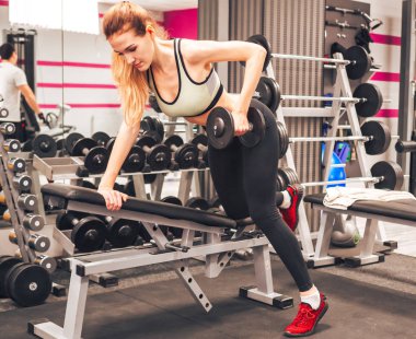 Genç kız spor salonunda egzersiz yapıyor.