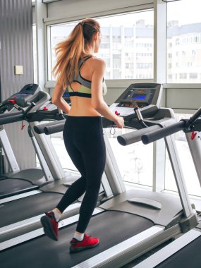 Genç kız spor salonunda egzersiz yapıyor.