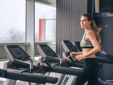 Genç kız spor salonunda egzersiz yapıyor.