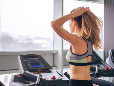 Genç kız spor salonunda egzersiz yapıyor.