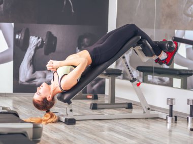 Genç kız spor salonunda egzersiz yapıyor.