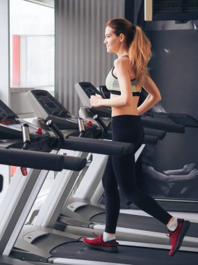 Genç kız spor salonunda egzersiz yapıyor.