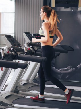 Genç kız spor salonunda egzersiz yapıyor.