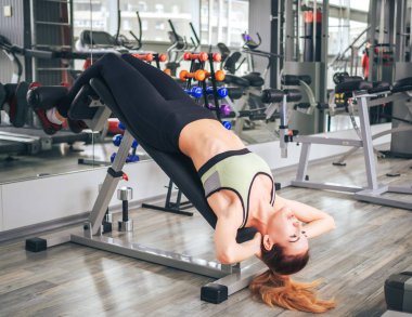 Genç kız spor salonunda egzersiz yapıyor.