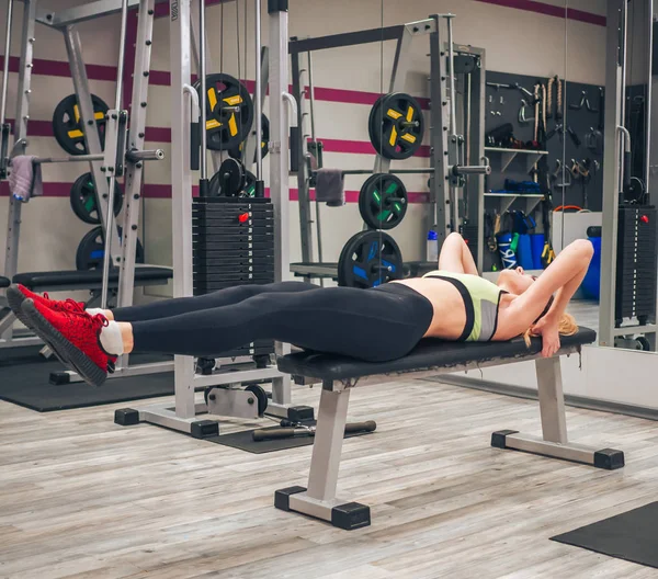 Genç kız spor salonunda egzersiz yapıyor.