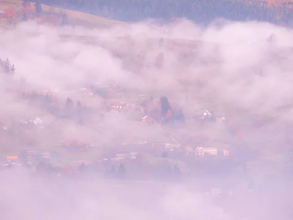Carpatian pueblo en las montañas en el soleado día de niebla — Foto de Stock