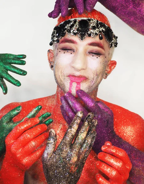 Man model at the red art make-up wears a black crown  looking at