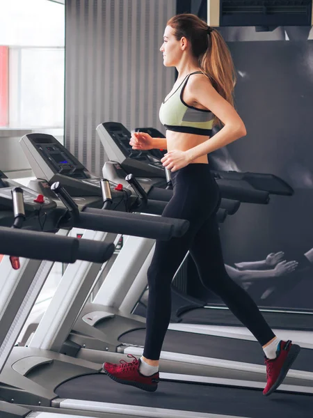 Genç kız spor salonunda egzersiz yapıyor.