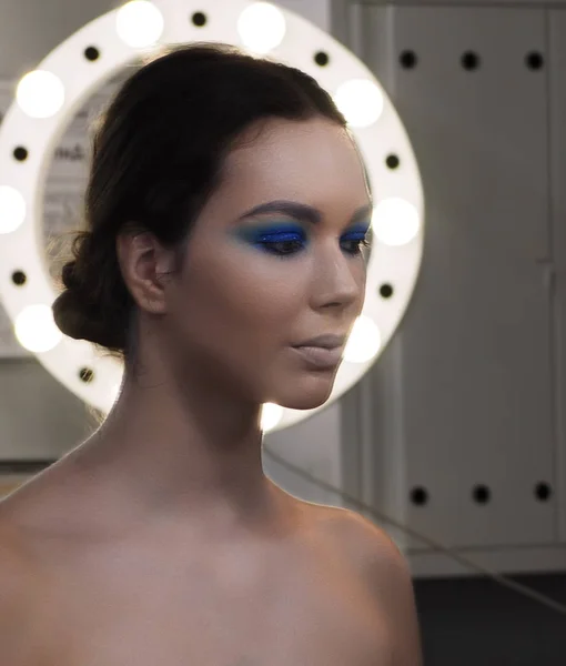 Model s make-up, který se dívá do kruhu světla — Stock fotografie