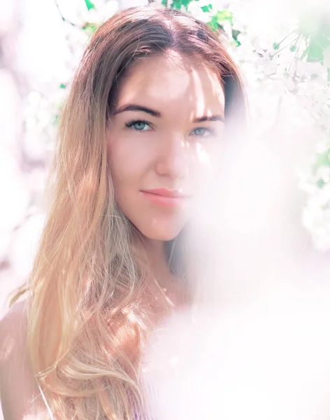 Portret van het jonge meisje aan de witte lente bloemen bloesem — Stockfoto
