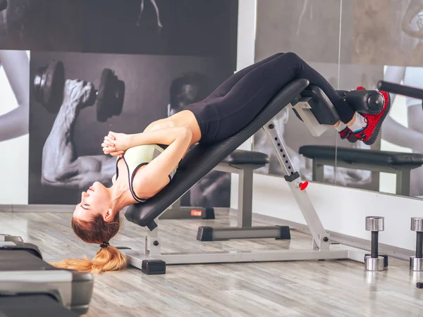 Genç kız spor salonunda egzersiz yapıyor.