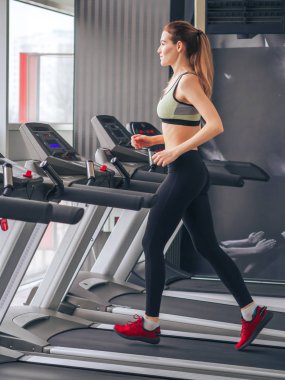 Genç kız spor salonunda egzersiz yapıyor.