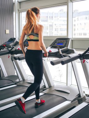 Genç kız spor salonunda egzersiz yapıyor.