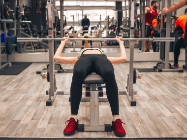 Genç kız spor salonunda egzersiz yapıyor.